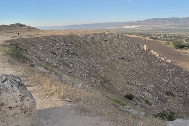 Ruins of a theater buried in a hillside.