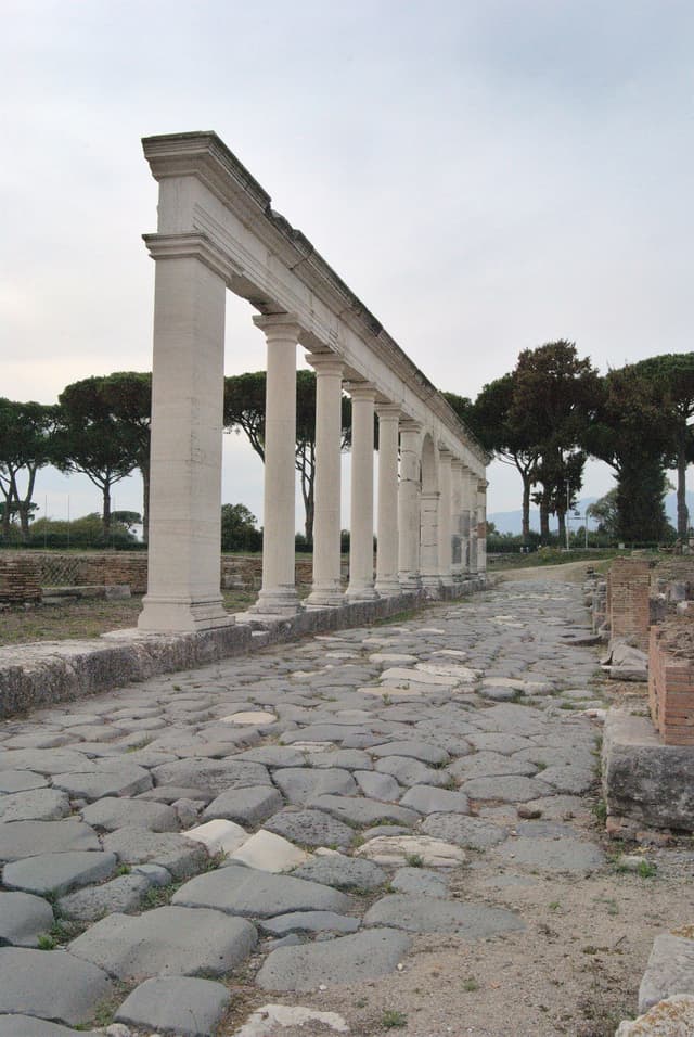 Original stone road of the Appian Way with a partially restored collonade.